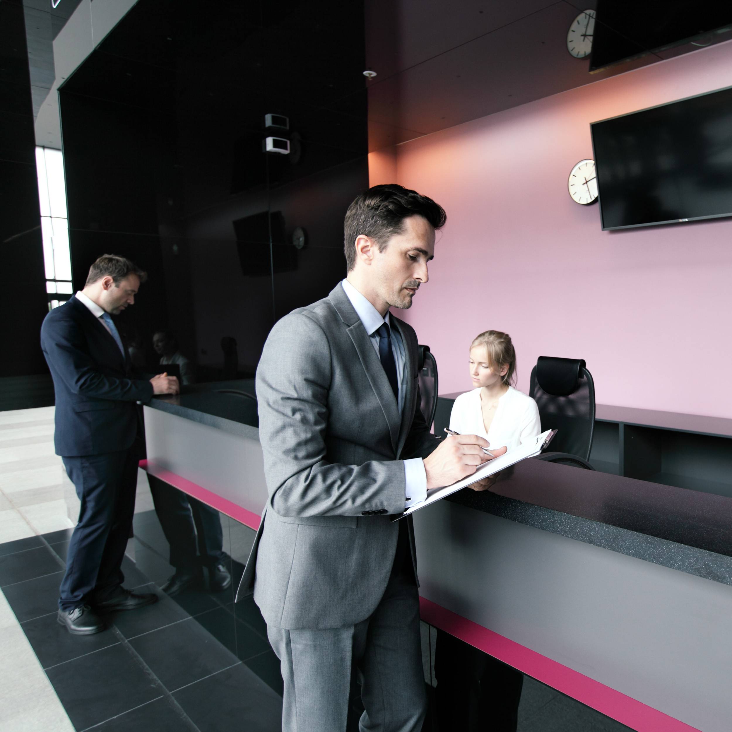 business people filling forms front desk min